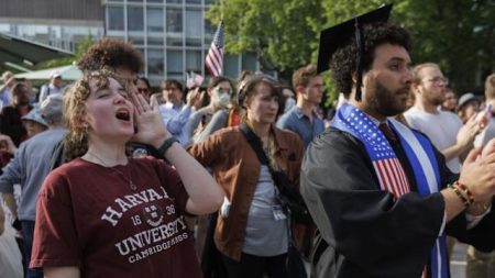 a man in a graduation cap and gown with a man in a cap and gown with a flag on his head
