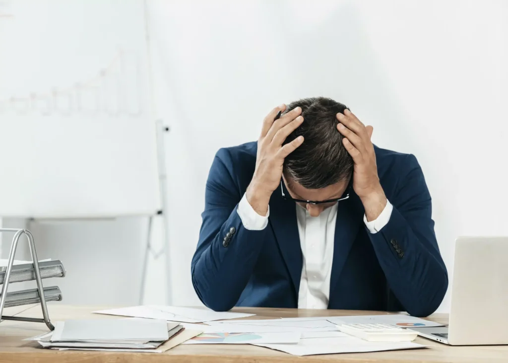 a man in a suit holding his head